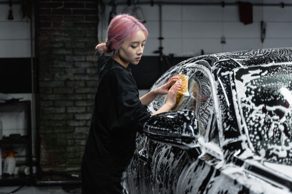 Friendly car wash professional wiping down a vehicle